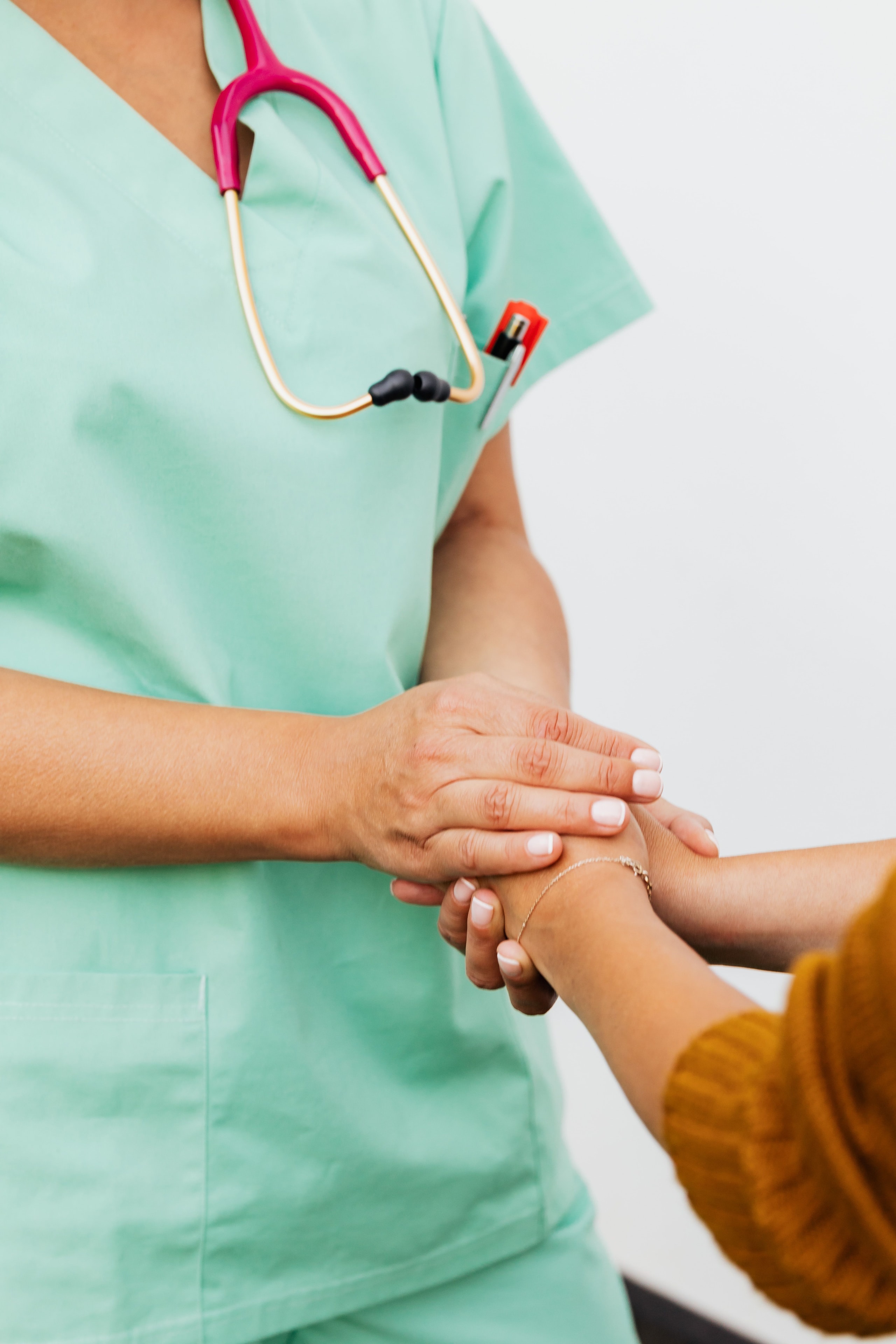 Nurse holding patient's hands with care