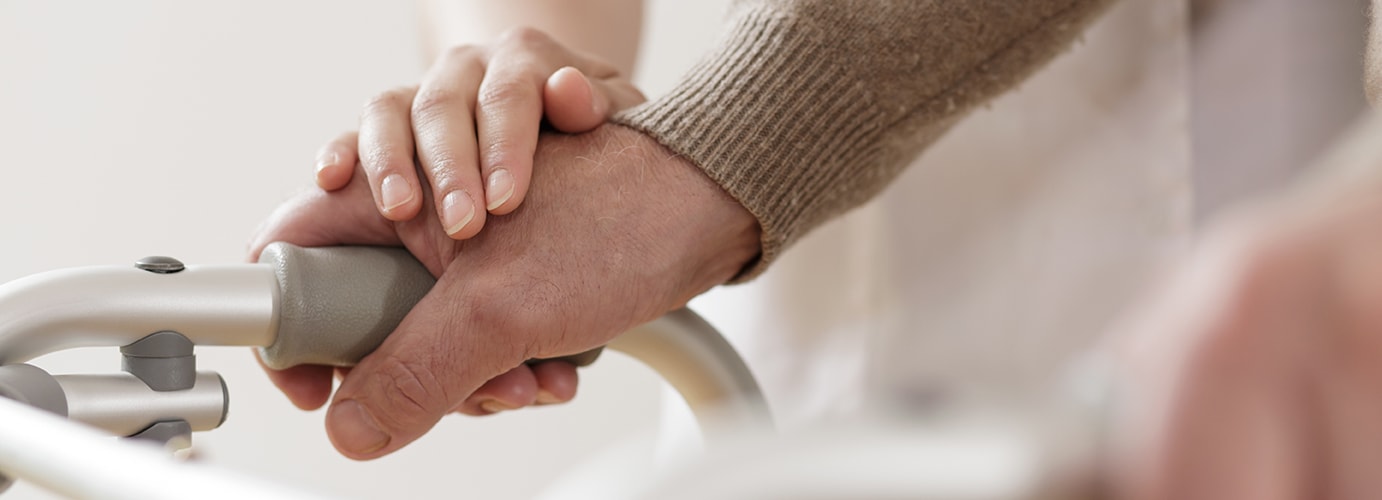 Caregiver holding a senior patient's hand for support